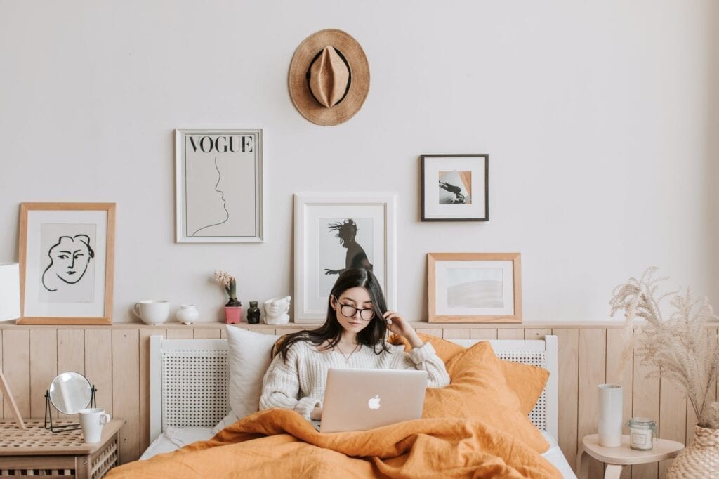 woman using laptop in bed to develop healthy morning routines