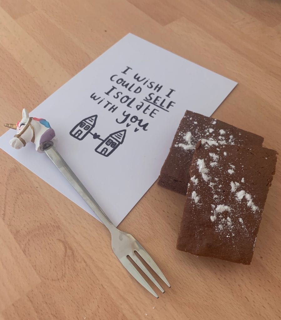 image of a unicorn fork alongside two slabs of brownie and a piece of card 'I wish I could self isolate with you