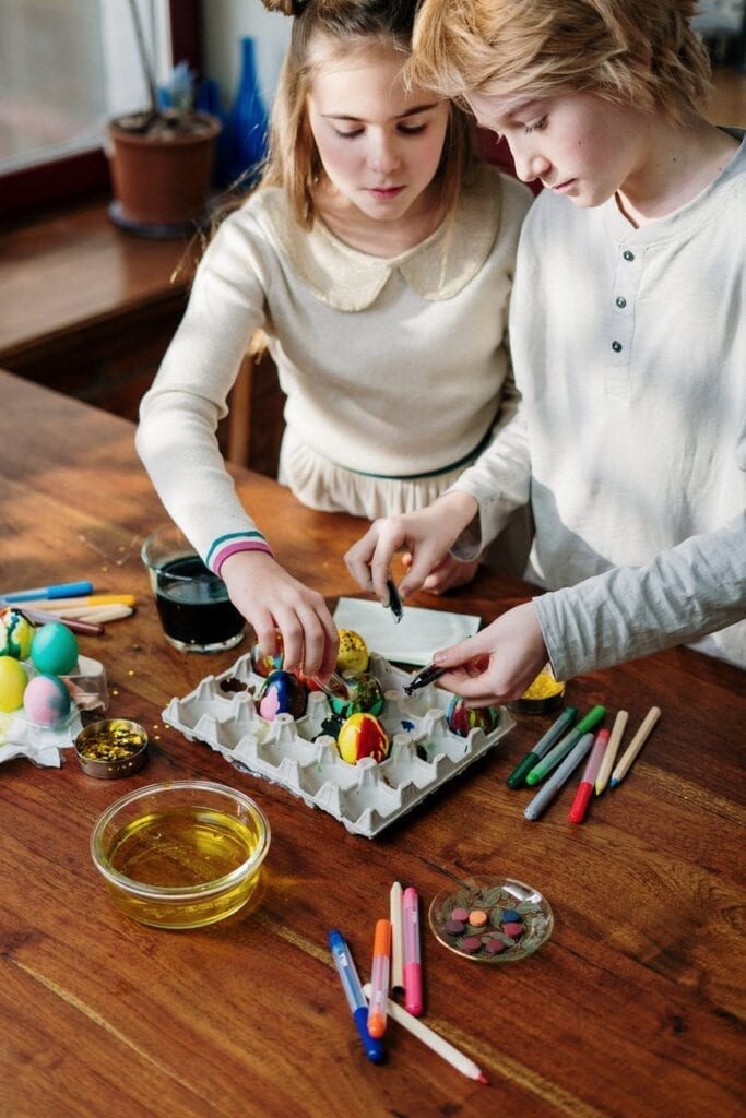 teenagers decorating eggs for easter