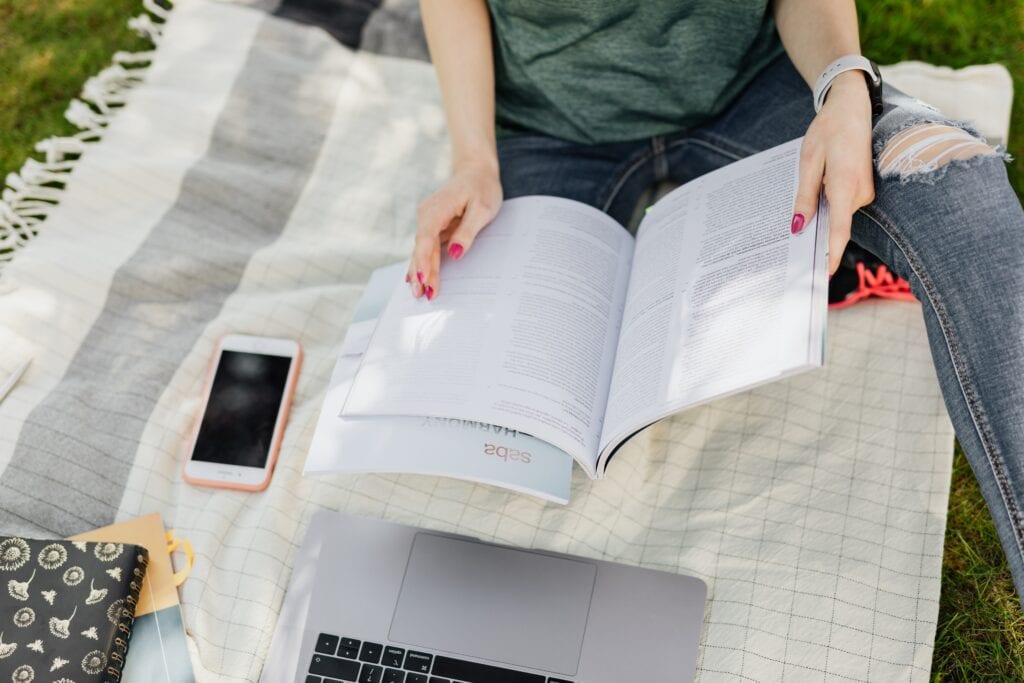 girl sitting on a blanket preparing to revise for GCSE success.