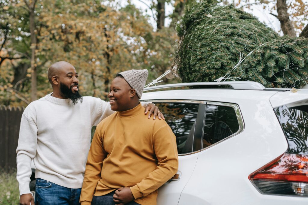 parenting twenty somethings - father and son stood by a white car.